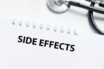 On the tablet for writing the text Side Effects, next to the stethoscope and white tablets.