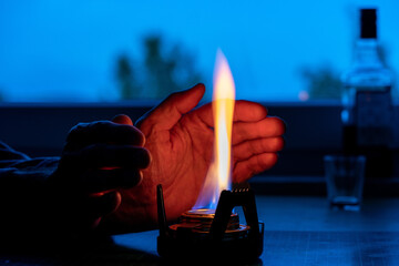 a man warmed his hands from an alcohol lamp in the absence of heating concept of the energy crisis...