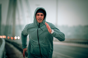 runner in motion fast running over the bridge at the winter snowy weather. Sportsman workout on...