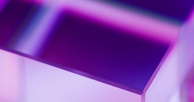 Neon light background. Glass cube rotation. Geometric figure. Defocused fluorescent purple pink color glow abstract free space for logo. Seamless loop. Shot on RED Cinema camera.