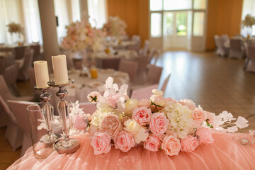 festive wedding table decoration with crystal chandeliers, golden candlesticks, candles and white pink flowers . stylish wedding day.