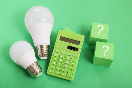 Light bulb, Green calculator, question mark on green background. Concept of competition for Green Energy market - Powered by Adobe