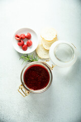Obraz na płótnie Canvas Raspberry jam or sauce with fresh rosemary