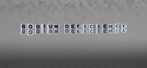sodium deficiency word or concept represented by black and white letter cubes on a grey horizon background stretching to infinity