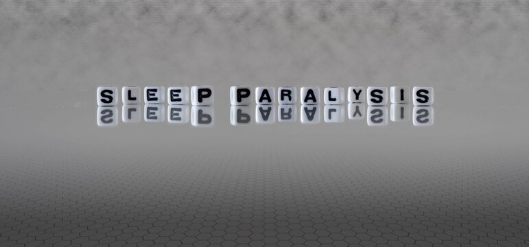 sleep paralysis word or concept represented by black and white letter cubes on a grey horizon background stretching to infinity