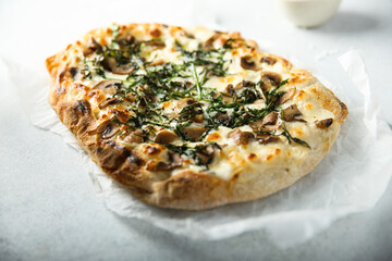 Homemade mushroom pizza with roasted arugula