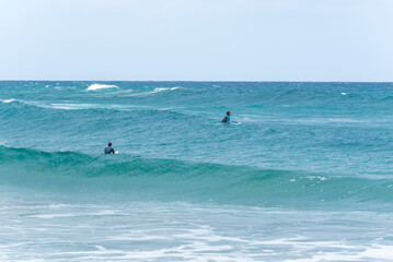 Two Surfers Sitting on Surfboard Waiting for a Wave Against the Horizon.Copy Space
