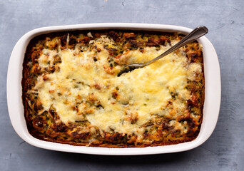 Casserole with cheese on a gray background. View from above.