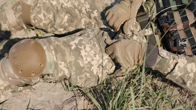 Combat medical tourniquet stops the flow of blood during a first aid procedure. A member of the military demonstrates how to use a combat medical tourniquet during first aid.