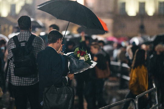 People mourn and bring flowers under the rain outside Buckingham Palace after Queen Elizabeth died