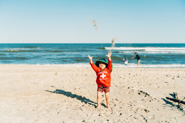 portrait of a cute boy playing at the beach in summer