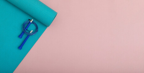 Top view on skipping rope and blue fitness mat. Healthy lifestyle and copy space, place for text...