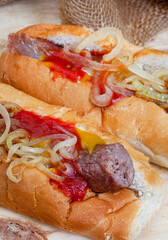 South African famous boerewors roll, juicy and topped with onions on a rustic surface