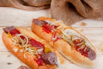 Fotobehang South African famous boerewors roll, juicy and topped with onions on a rustic surface © Aninka