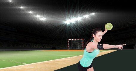 Young caucasian female handball player pointing while playing at illuminated stadium
