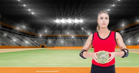 Focused caucasian female player holding ball while looking away at illuminated stadium