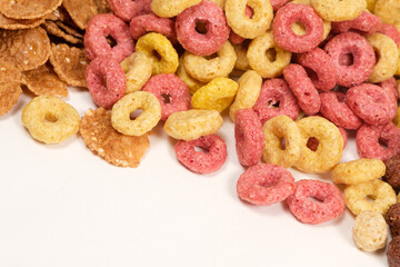 Cereals from corn in the form of multi-colored rings on a white background.