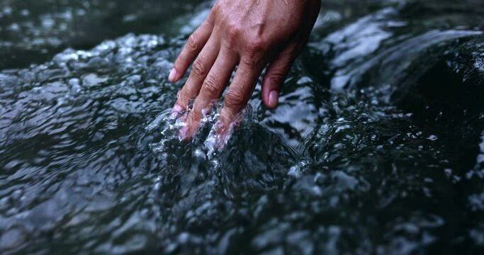 Stream water flowing on hand.