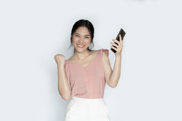 Naklejka premium Asian beautiful woman is holding smartphone and smiling with a happiness for shopping online or wining.