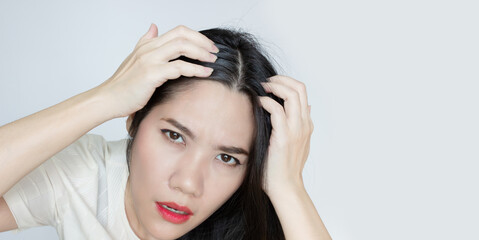 Fototapeta premium Asian Beautiful woman use hand touch her head and looking to check grey hair with worry face.