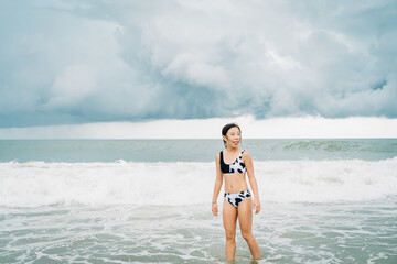 portrait of an asian girl playing at the beach in summer