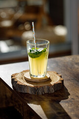 Fantastic citrus cocktail mojito in a glass with organic straw and no alcohol on a wood background. view with copy space.