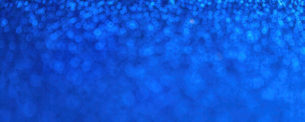 Blurred navy blue sparkling background from small sequins, macro. Sapphire defocused backdrop
