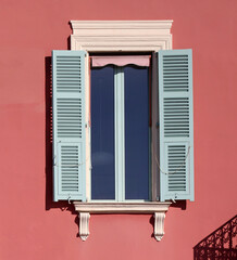 Typical facade in the south of France, on the French Riviera, windows with colored shutters