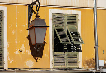 Typical facade in the south of France, on the French Riviera, windows with colored shutters