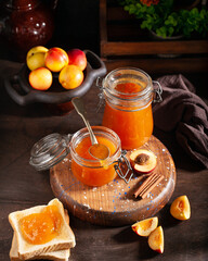 apricot jam in glass jars on a dark table in rustic style. preparations for winter, rustic, farm food, farm products, confectionery concept