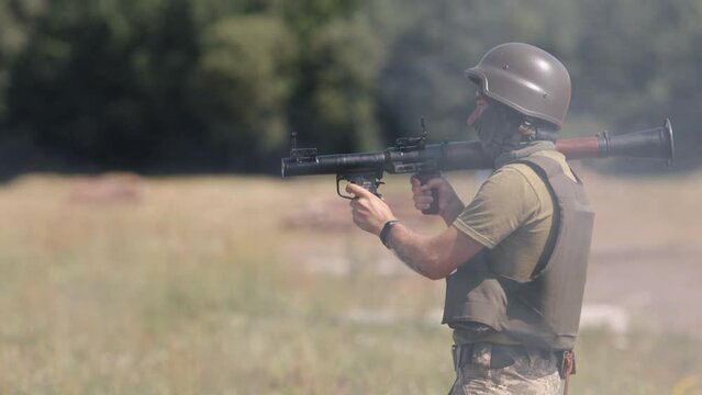 With a precision rocket on target, a soldier in a helmet and military uniform shoots a Precision Shoulder-Fired Rocket Launcher RPG-7 PSRL-1 at the enemy