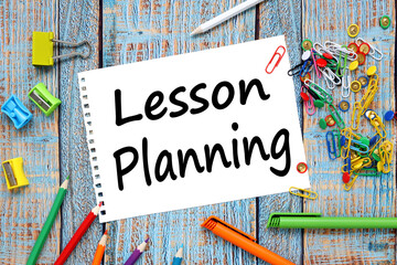multi-colored stationery scattered on a blue wooden background. text on notepad. LESSON PLAN