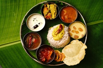 Kerala Ona sadya Onam feast - vegetarian thali served on a round plate with banana leaf