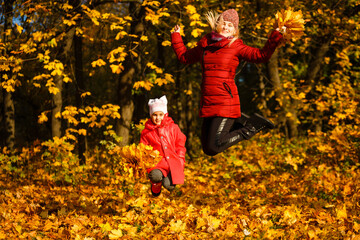 Young mother with her little daughter in an autumn park