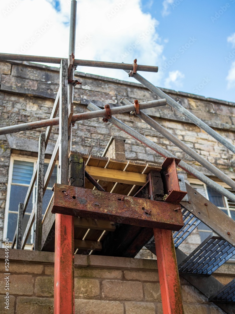 Poster stair case on outside of building made from scaffolding