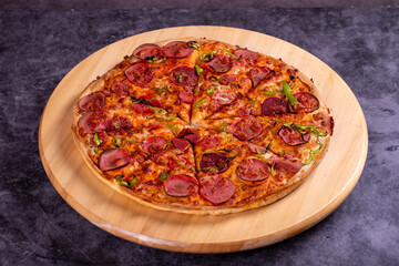 Pizza. Traditional Italian cuisine delicacies. pizza with sausage on dark background