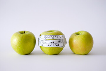 Green apple with white measurement tape