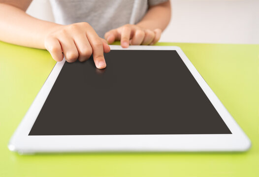 Shot of a little kid using a digital tablet with tablet computer on green background with copy space.