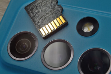 micro sd card lies on the block of smartphone cameras. close-up