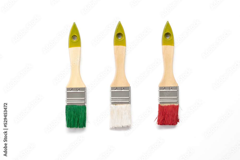 Wall mural paint brushes on white background. flat lay. paintbrushes in the colors of the national flag of ital