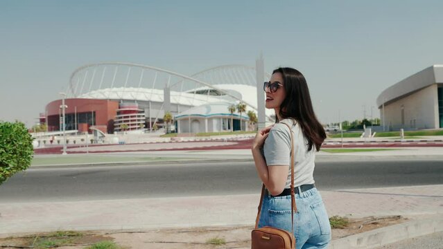 Happy Woman soccer fan in front international stadium in Doha, Qatar. 2022 FIFA World Cup.
