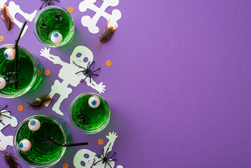 Halloween concept. Top view photo of glasses with green floating eyes punch skeleton silhouettes spiders centipedes cockroaches pumpkin shaped confetti on isolated violet background with copyspace