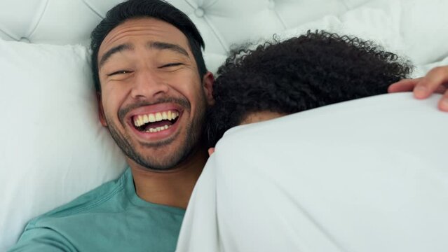 Couple selfie, laughing and happy man waking up a sleeping woman as a comic prank. Funny male from Israel taking a picture together while a female sleep and wake up to see the camera in bedroom bed