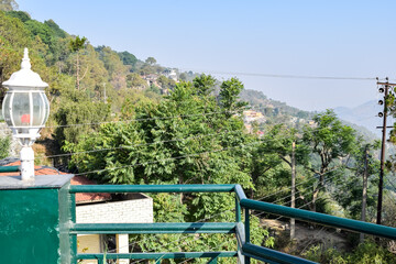Fototapeta na wymiar Early morning view of Modern rooftop restaurant at Kasauli, Himachal Pradesh in India, View of mountain hills from open air restaurant in Kasauli, Kasauli Rooftop restaurant