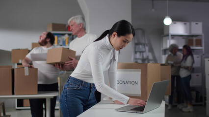Charity organization manager work on laptop in warehouse