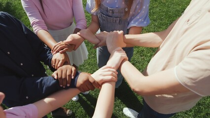 Cropped shot of diverse students make circle with hands outdoors