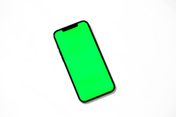 Smartphone with blank green screen isolated on white background.