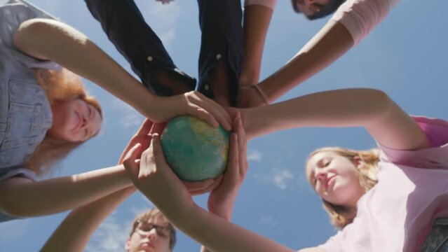 Bottom view of children holding the earth: the future is in their hands