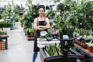 Shot of a young woman working with plants in a garden centre