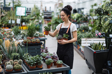 Shot of a young woman working with plants in a garden centre